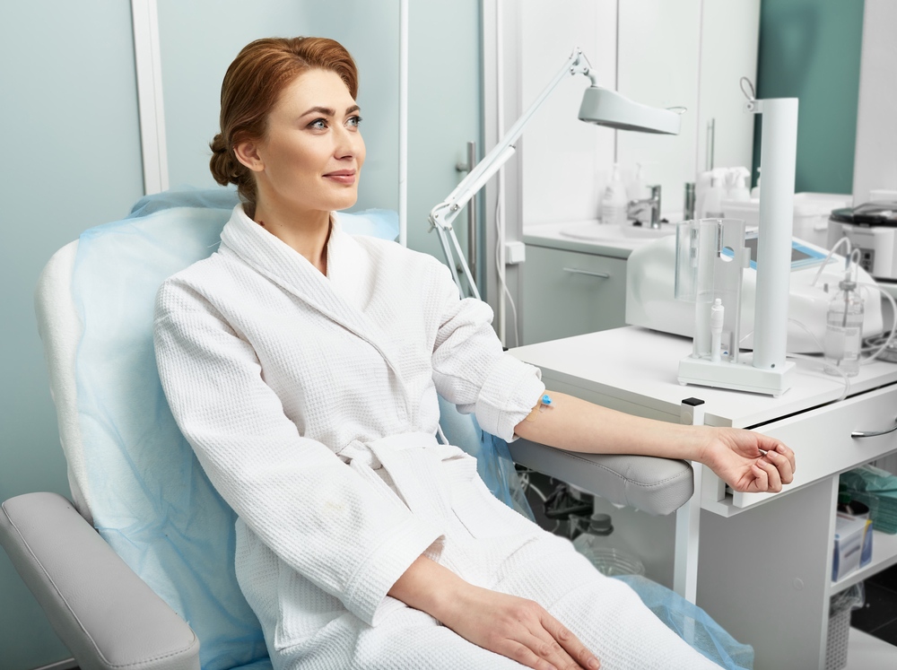 Woman in white robe receiving ozone therapy for recovery session at a wellness clinic