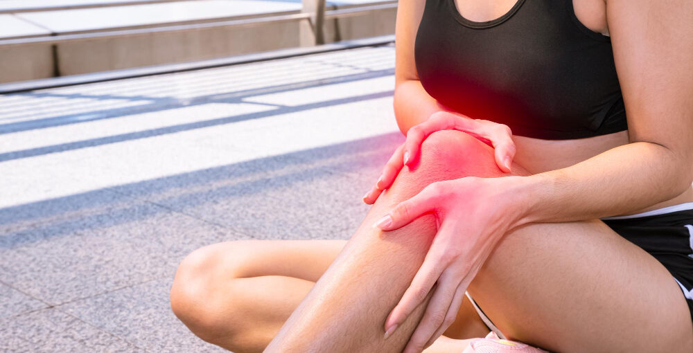 Female athlete holding inflamed knee illustrating the need for ozone therapy for joint pain
