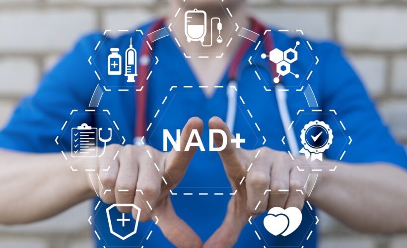 Healthcare provider in blue scrubs displaying a digital NAD+ graphic representing NAD+ IV therapy benefits and applications