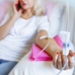 Woman relaxing and talking on phone while receiving an IV drip during an IV therapy for athletes recovery session